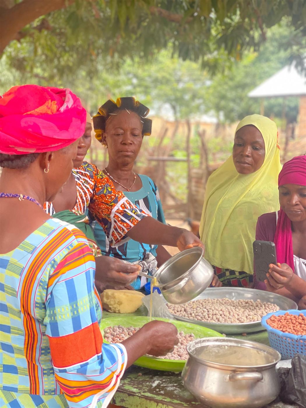 Women measuring and buying groundnuts from farmers