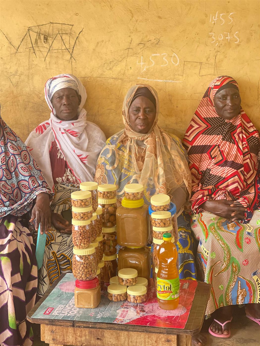 Women from a farmers' group holding jars of Influx groundnut products